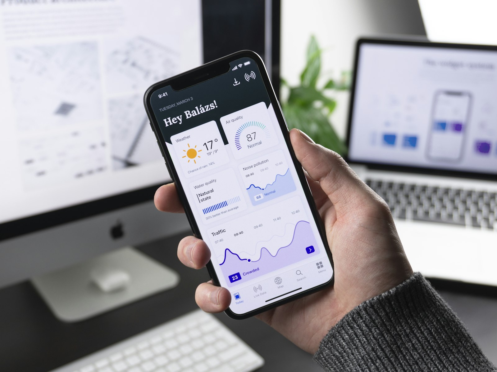 Hand holding a smartphone showing a dashboard app
