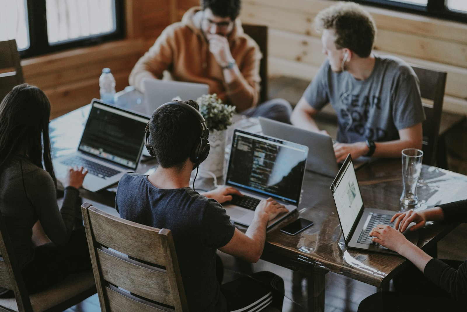 Developers collaborating around a table with laptops